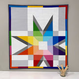Stellar Translucence quilt hanging on the wall with colored pencils in front in a jar